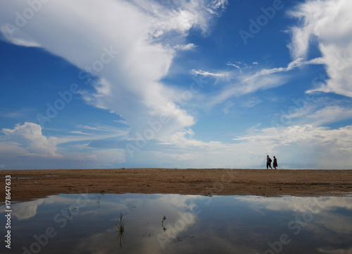 some one walking on the beach with puddle
