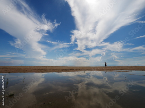 some one walking on the beach with puddle