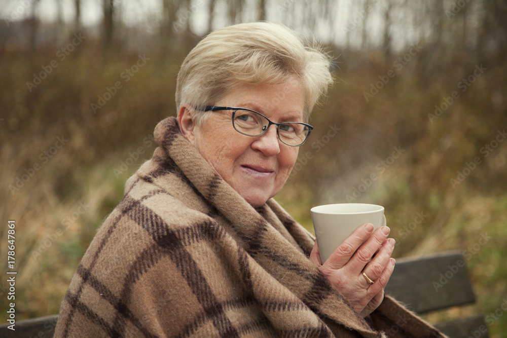 grandmother sitting on a Park bench on a grass background grandmother sitting on a Park bench on a grass background