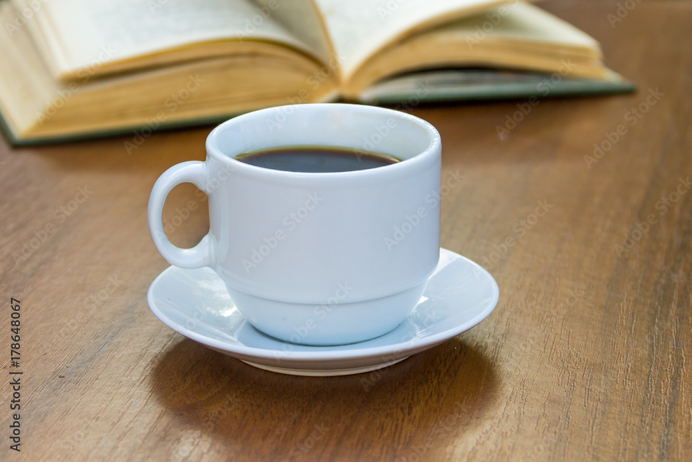 Cup of coffee and book on wooden table Cup of coffee and book on wooden table