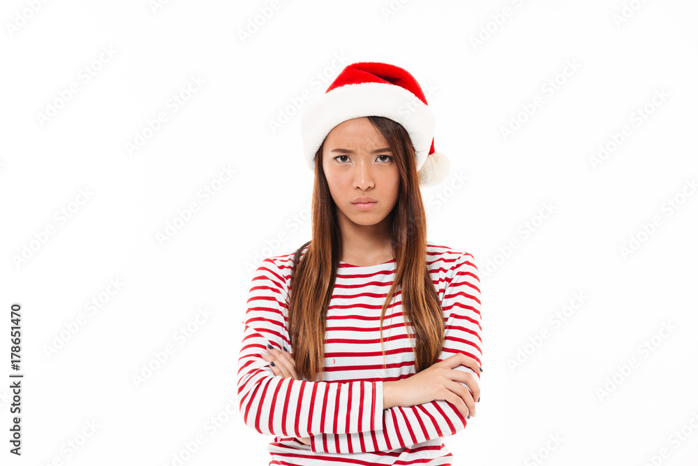 Portrait of an upset asian girl in christmas hat Portrait of an upset asian girl in christmas hat