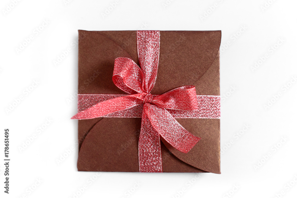 Christmas gift wrapped in brown paper with the bow top view isolated on white background Christmas gift wrapped in brown paper with the bow top view isolated on white background