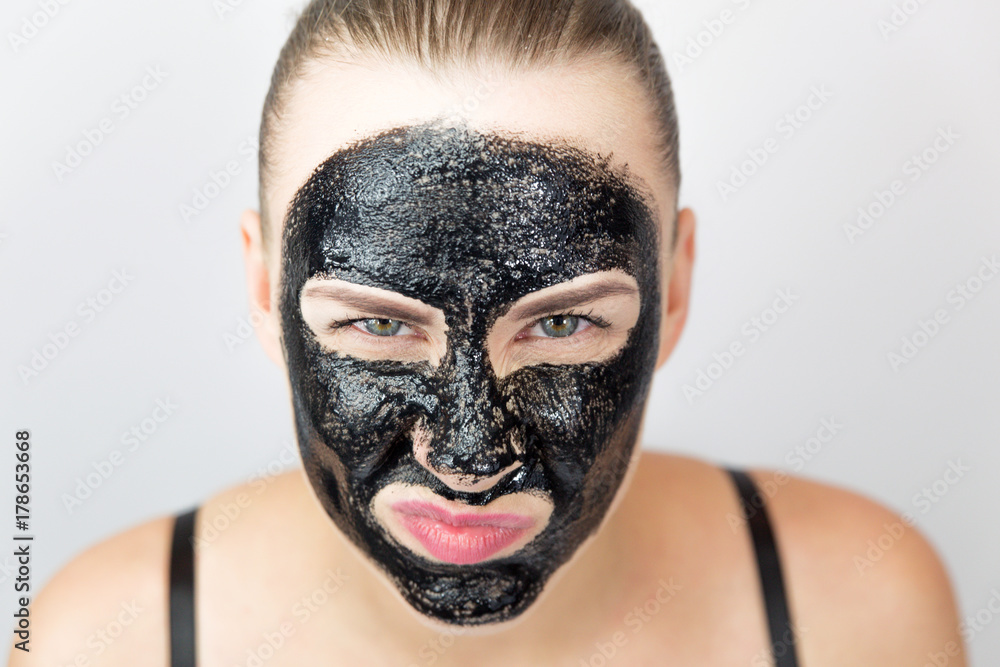 Woman with purifying black mask on her face
Woman with purifying black mask on her face