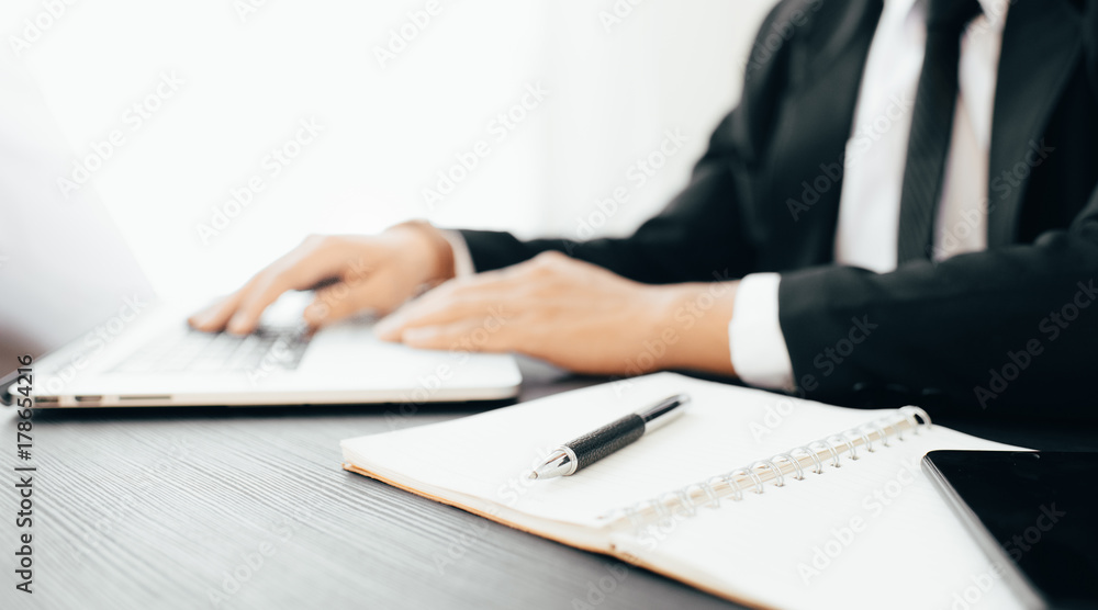 Side view shot of a man's hands using smart phone in interior, rear view of business man hands busy using cell phone at office desk Side view shot of a man's hands using smart phone in interior, rear view of business man hands busy using cell phone at office desk