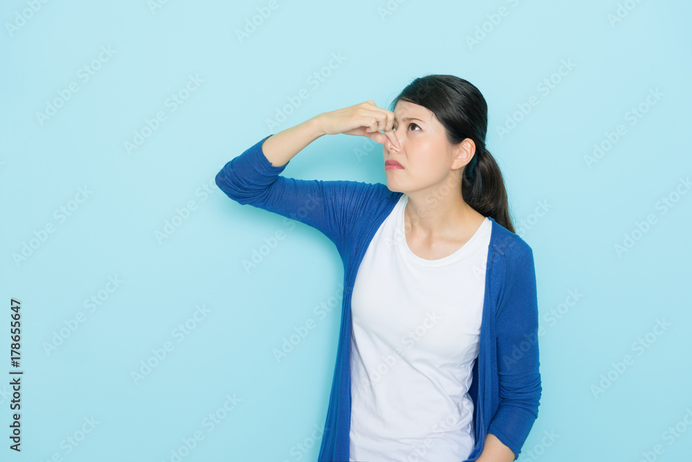 woman smelling bad odor using hands closing nose woman smelling bad odor using hands closing nose