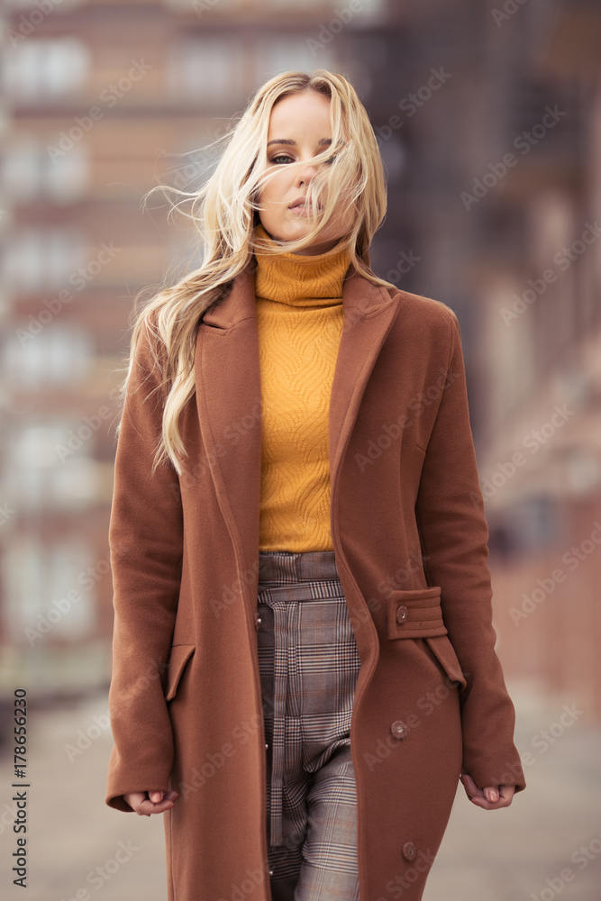 Blonde woman wearing in stylish coat in city Blonde woman wearing in stylish coat in city