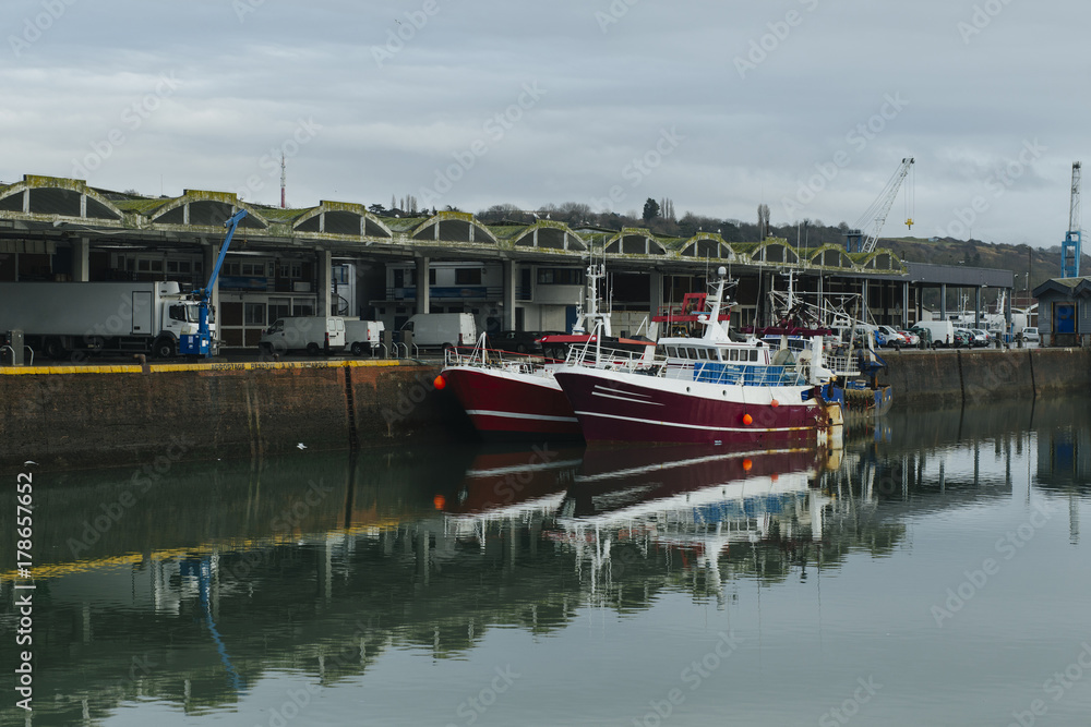 Fototapeta premium Fishing boats in a harbor. Trawler after fishing. Fishing industry, fishery. Commercial ship for seafoods in Dieppe, Normandy