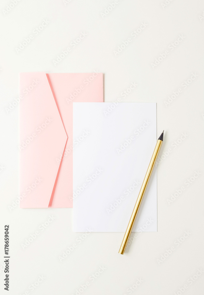 Pink envelope, blank paper, golden pencil on white background Pink envelope, blank paper, golden pencil on white background