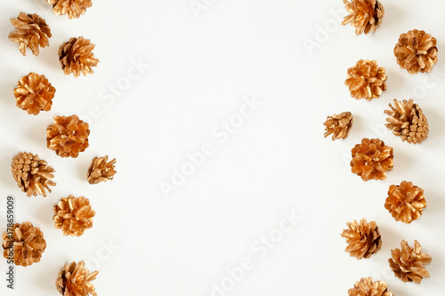 Golden pine cones on white background