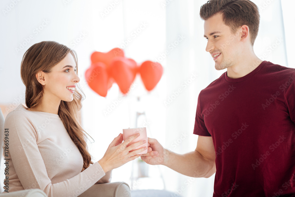 Mindful guy bringing cup of tea for girlfriend Mindful guy bringing cup of tea for girlfriend