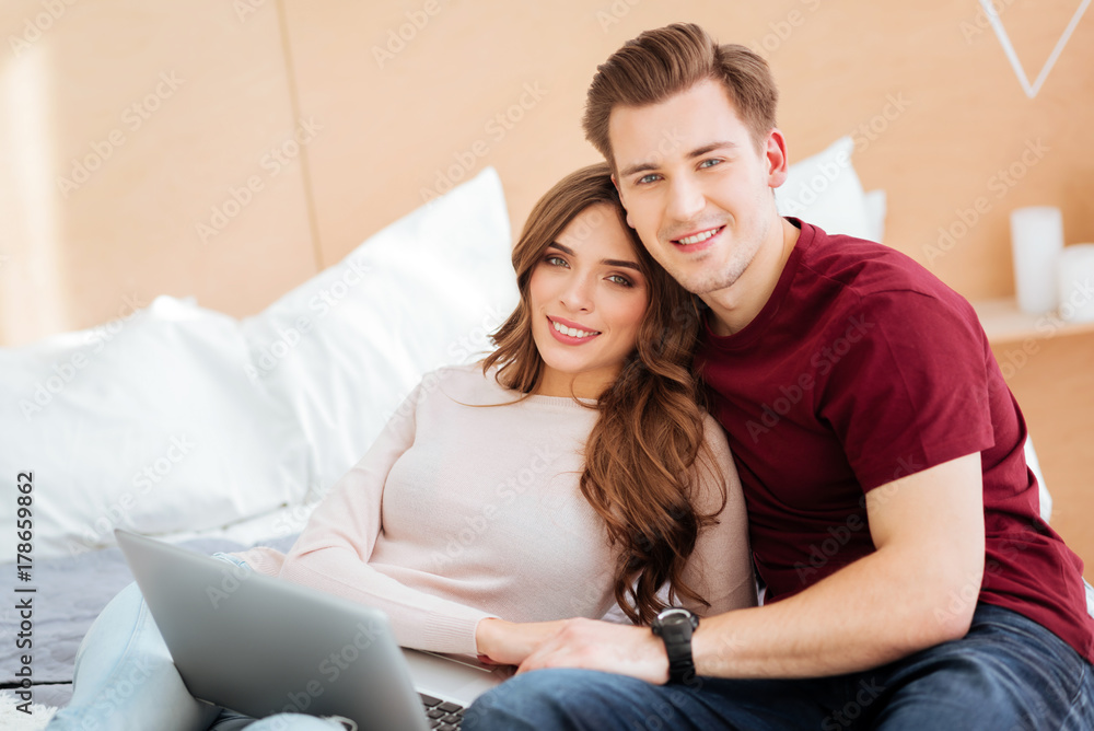 Thoughtful couple embracing tightly and smiling Thoughtful couple embracing tightly and smiling