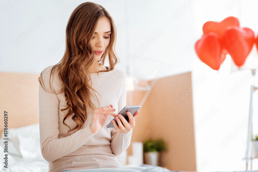 Focused lady typing something on smartphone Focused lady typing something on smartphone