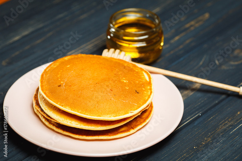 Tasty healthy breakfast - fresh pancakes with honey photo