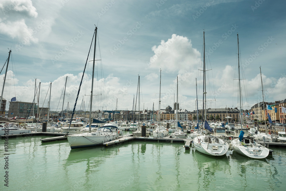 Yachts moored at quay port of Dieppe, France. Concepts of success, leisure, holiday, rich, tourism, luxury, lifestyle. Sunny Summer, blue sky. Toned