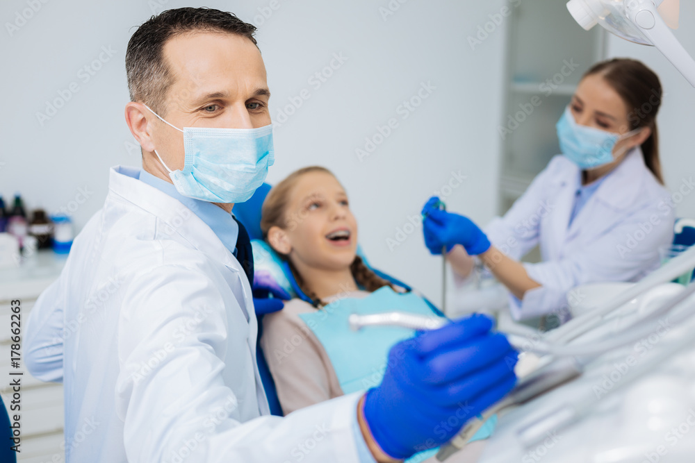 Positive skillful dentist working with his colleague Positive skillful dentist working with his colleague