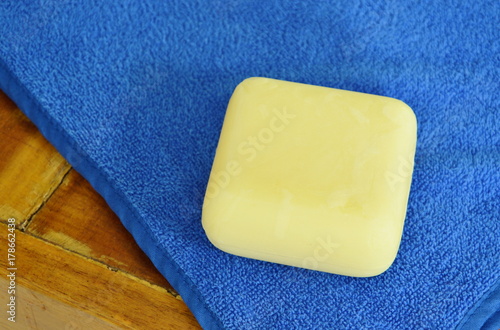 yellow soap and blue towel on wooden table