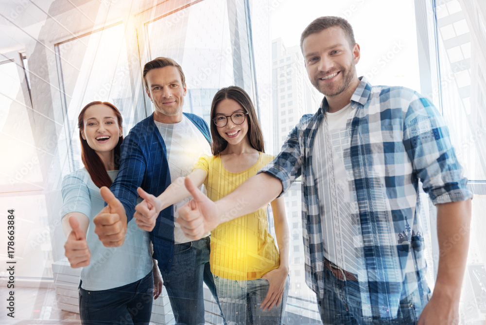 Obraz premium Happy young people raising their thumbs