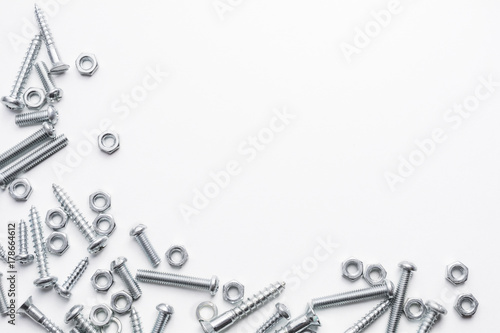 Collection Of Iron Screws, Nuts and Lockwashers At The Left und Bottom Border Of A Whitebox photo