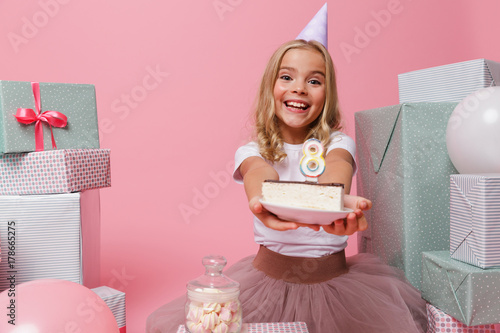 Photography Portrait of an excited little girl in a birthday hat