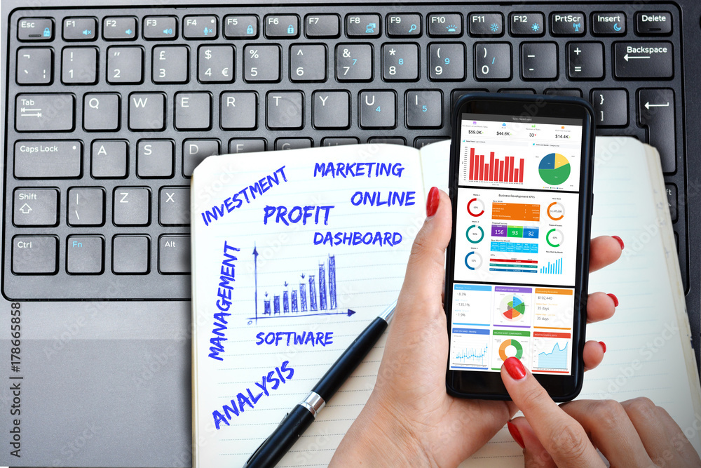 Business intelligence, software graphs dashboard on smartphone with laptop keyboard and handwritten agenda Business intelligence, software graphs dashboard on smartphone with laptop keyboard and handwritten agenda