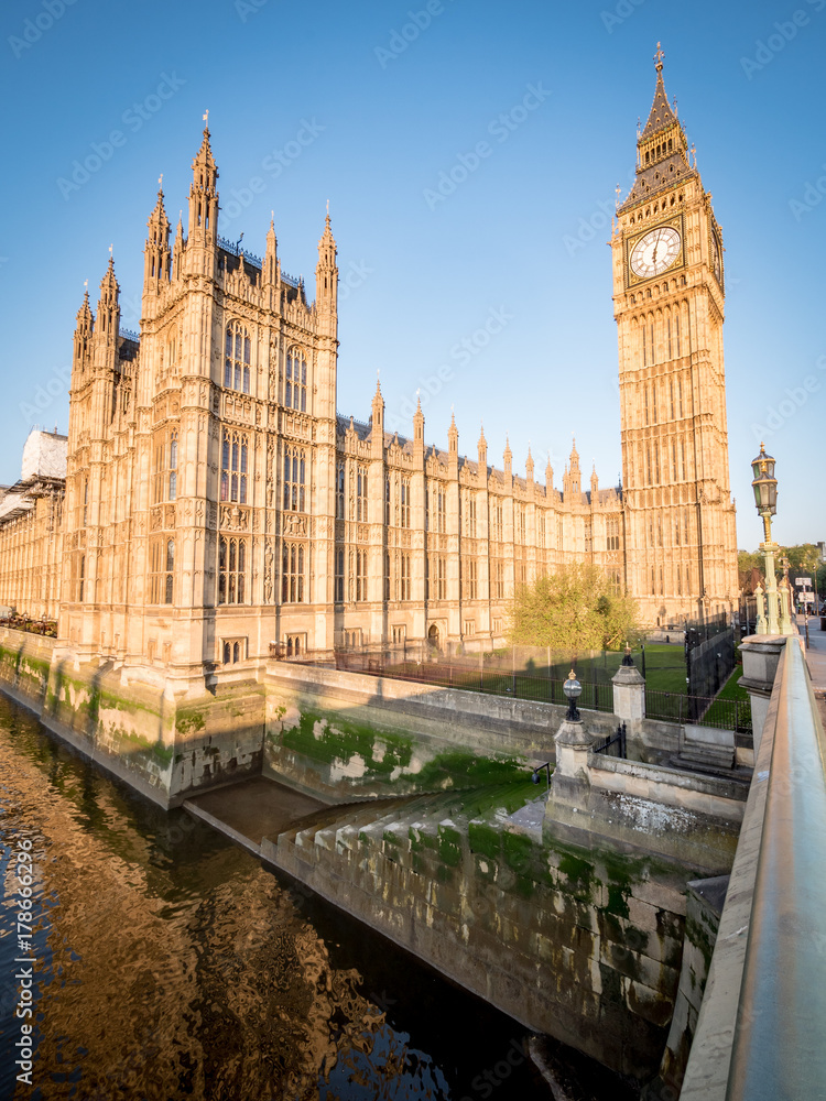 Naklejka premium Big Ben and the Palace of Westminster. Low angle view of the famous clock tower London landmark in the early morning sun.