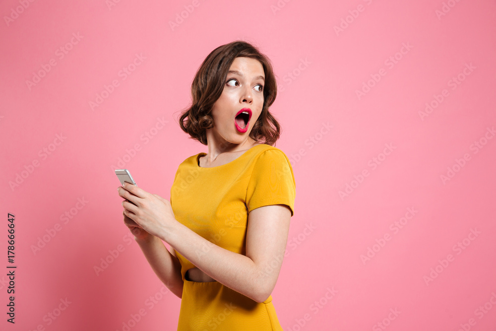 Portrait of a surprised young woman holding mobile phone Portrait of a surprised young woman holding mobile phone