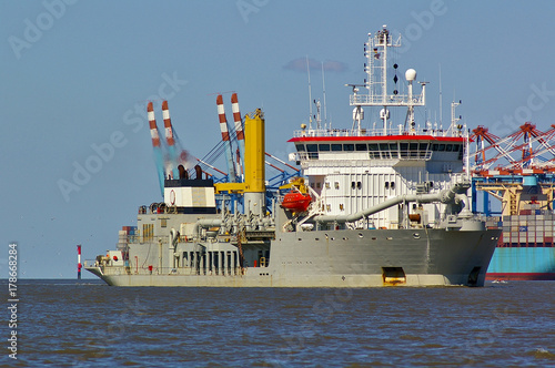 Foto Trailing suction hopper dredger in the Weser estuary with container vessel and p