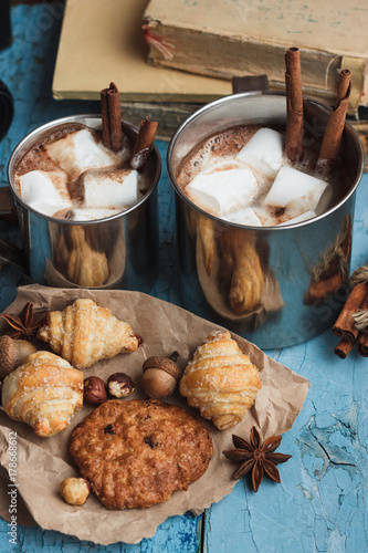 Metal cups with cacao and marshmallow and different cookies