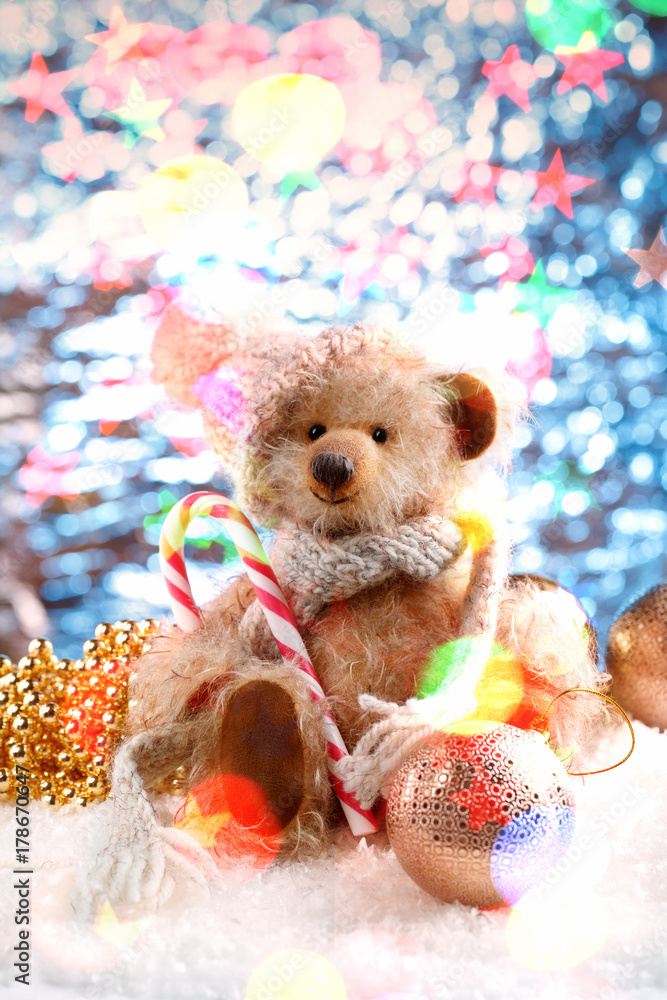 Teddy bear in a winter hat and Christmas decorations on snow Teddy bear in a winter hat and Christmas decorations on snow