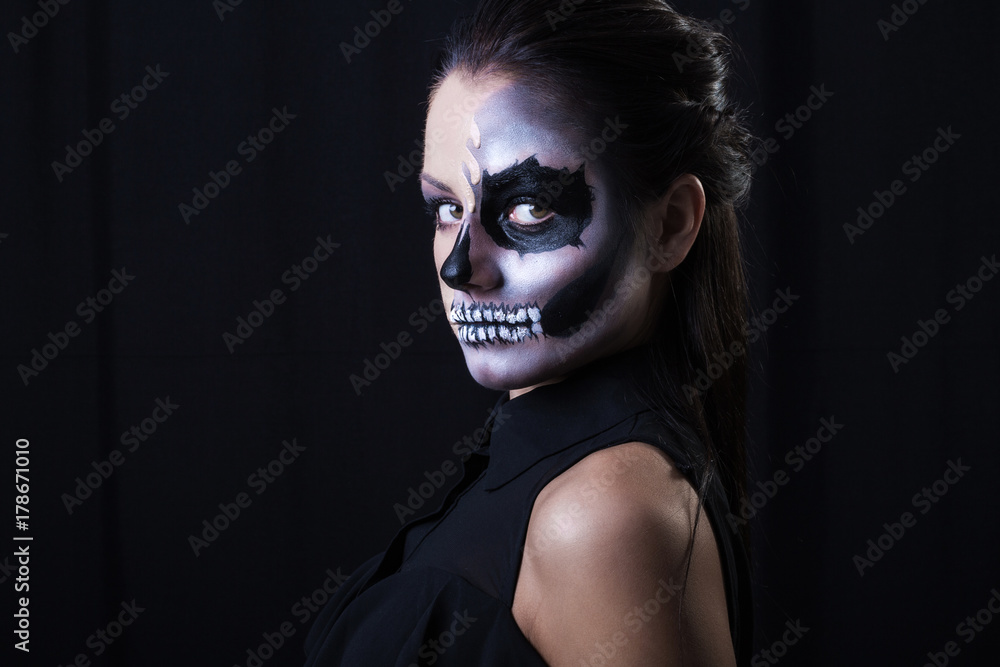 Halloween. Portrait of young beautiful girl with make-up skeleton on her face Halloween. Portrait of young beautiful girl with make-up skeleton on her face