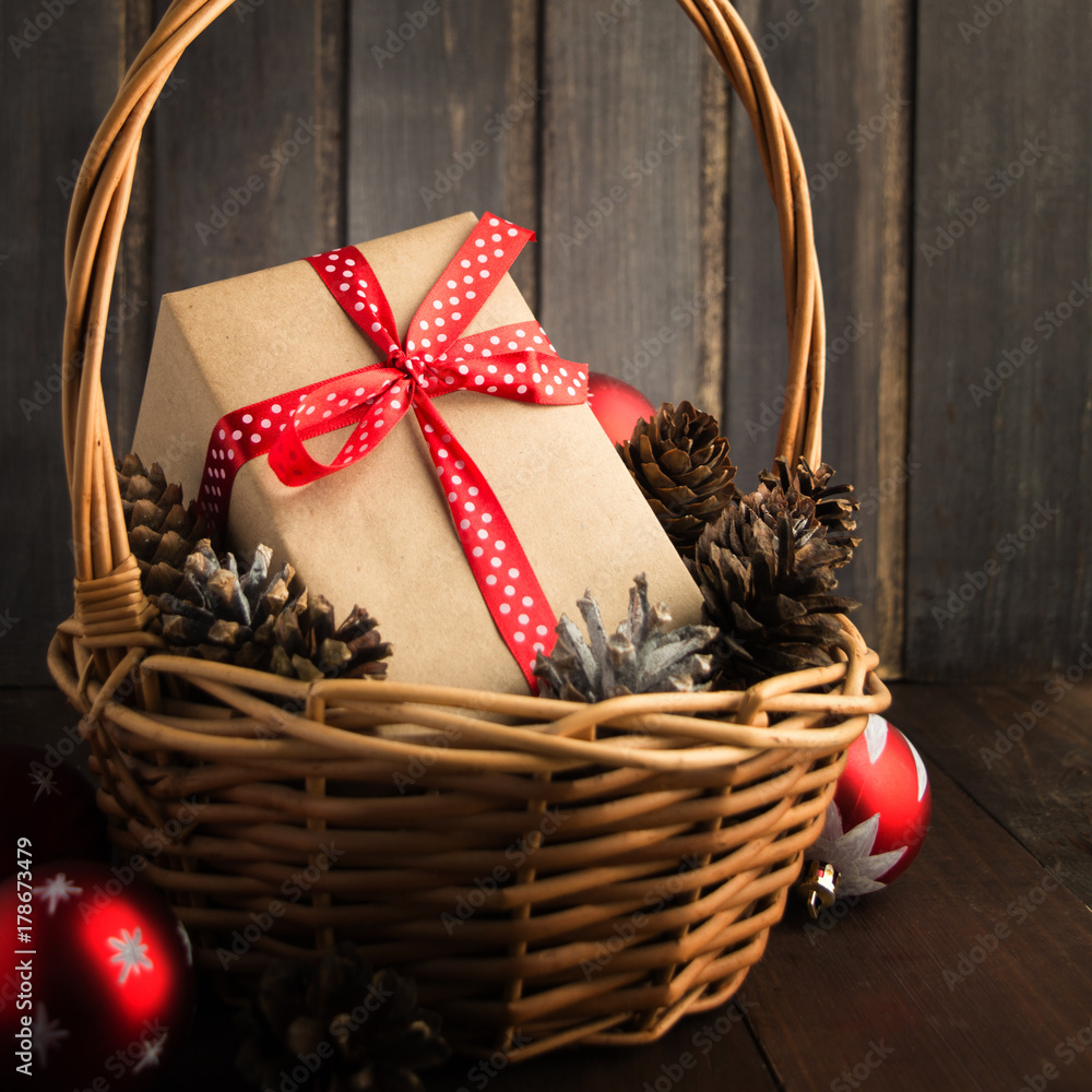 Christmas present in basket with cones and balls