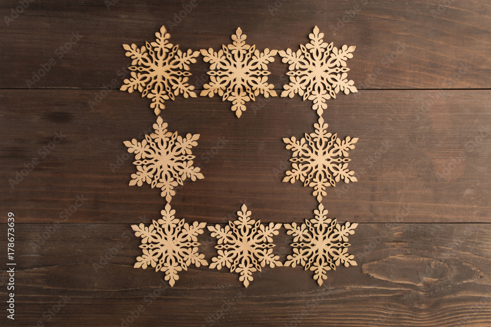 Square wooden snowflake frame design on wooden table Square wooden snowflake frame design on wooden table