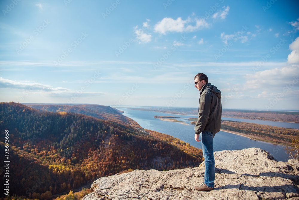 a man stands on top of a mountain admiring the scenery