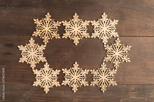Oval wooden snowflake frame design on wooden table