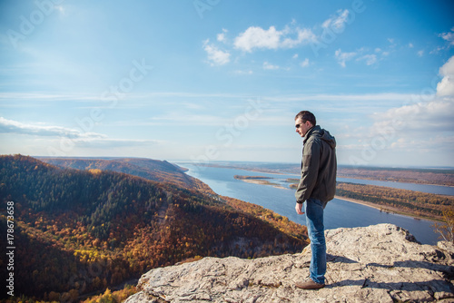 a man stands on top of a mountain admiring the scenery
