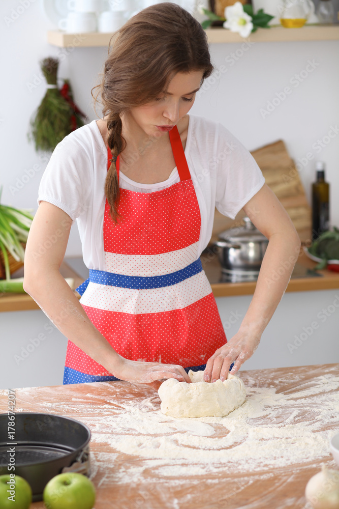 Female hands making dough for pizza or bread on wooden table. Baking concept 