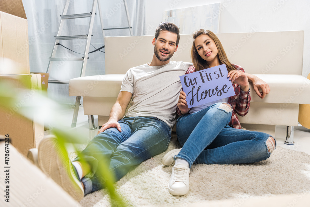 couple with our first house sign couple with our first house sign