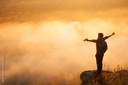 Man on stone above clouds
