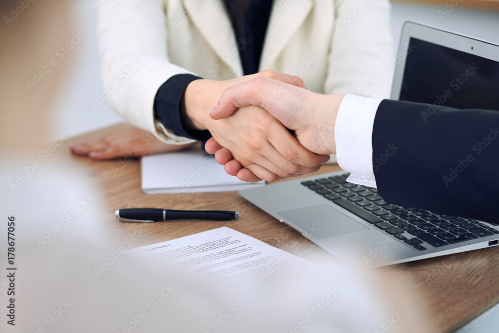 Close up of business people shaking hands at meeting or negotiation in the office. Partners are satisfied because signing contract Close up of business people shaking hands at meeting or negotiation in the office. Partners are satisfied because signing contract