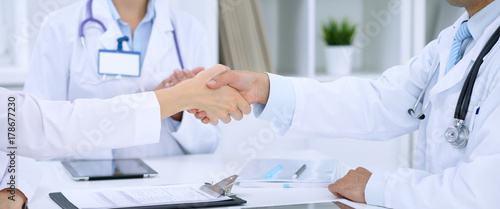 Doctors shaking hands to each other finishing up medical meeting photo