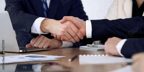 Close up of business people shaking hands at meeting or negotiation in the office. Partners are satisfied because signing contract © rogerphoto