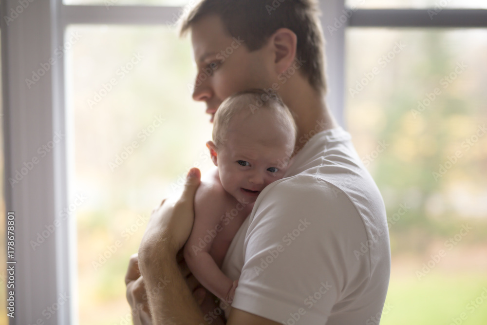 happy family father with newborn baby in front of window happy family father with newborn baby in front of window
