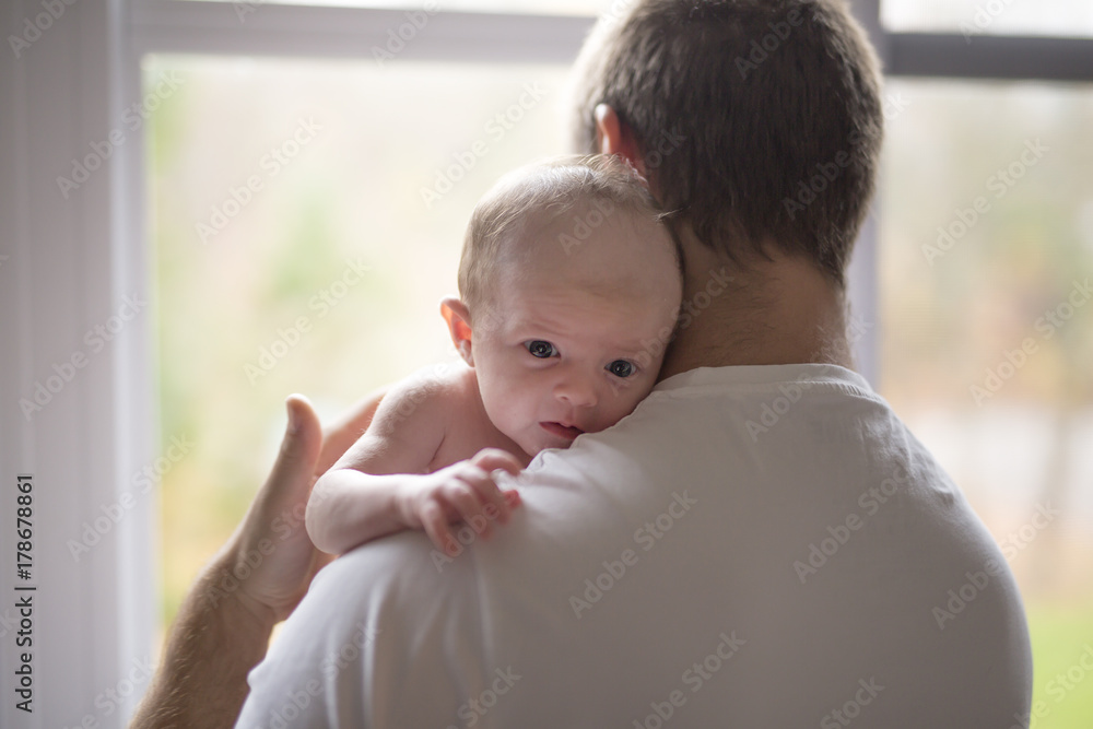 happy family father with newborn baby in front of window happy family father with newborn baby in front of window