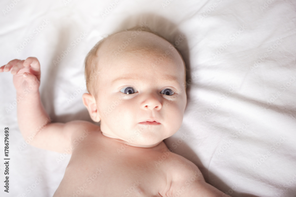 Peaceful baby lying on a bed on parent room Peaceful baby lying on a bed on parent room