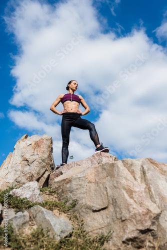 athletic woman standing on rocks