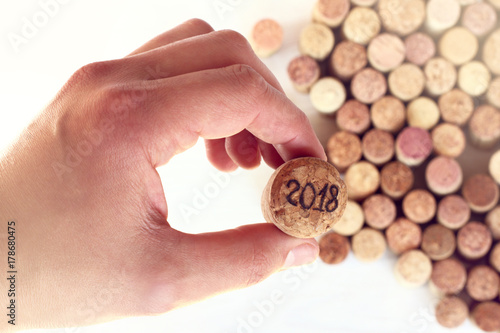 celebration of special date  number 2018 on wine cork in his hand