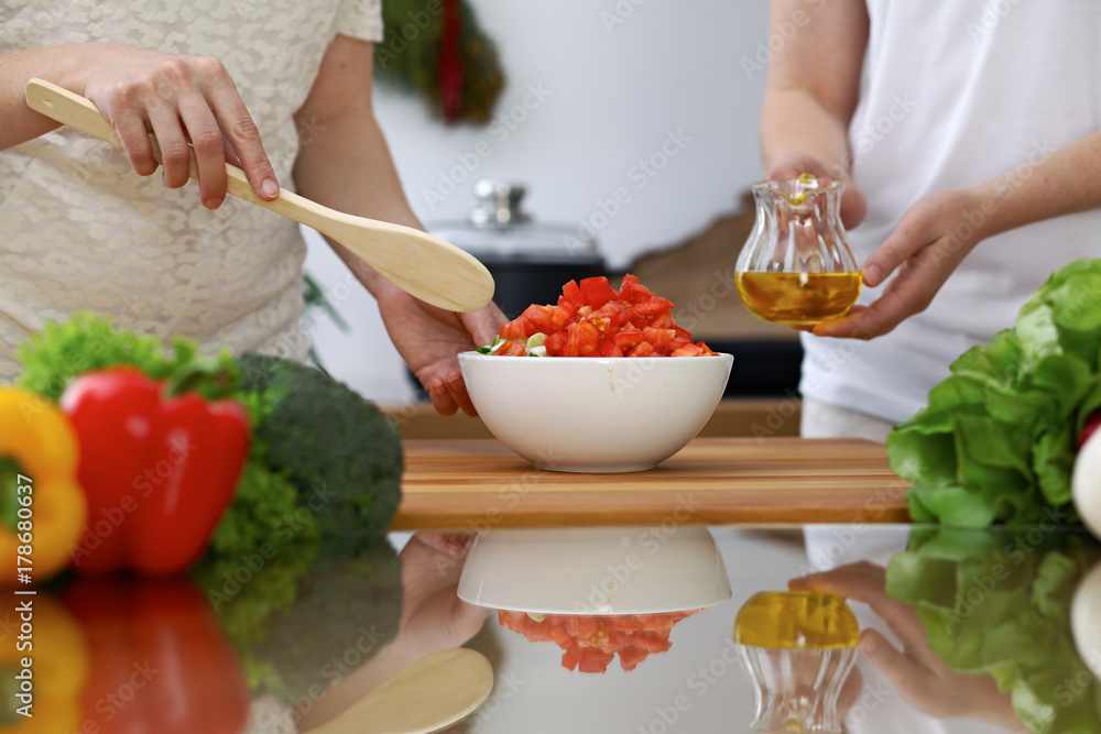 Close-up of human hands cooking in a kitchen. Friends having fun while preparing fresh salad. Vegetarian, healthy meal and friendship concept Close-up of human hands cooking in a kitchen. Friends having fun while preparing fresh salad. Vegetarian, healthy meal and friendship concept