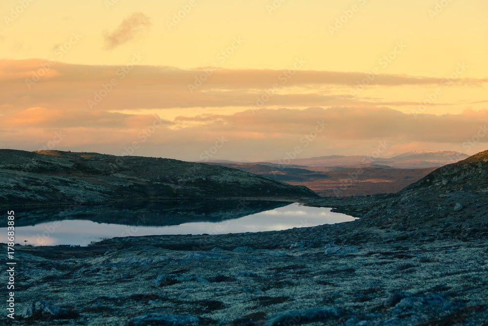 A beautiful mountain lake high above the sea level in Norway. Colorful autumn landscape with lake.