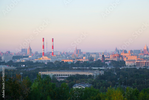 the skyline of a large city at sunset. Residential houses  industrial pipe
