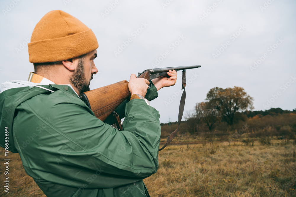 hunter aiming at something with gun